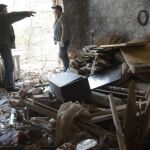 Dos personas charlan en una de las casas destruidas por un bombardeo en Donetsk.