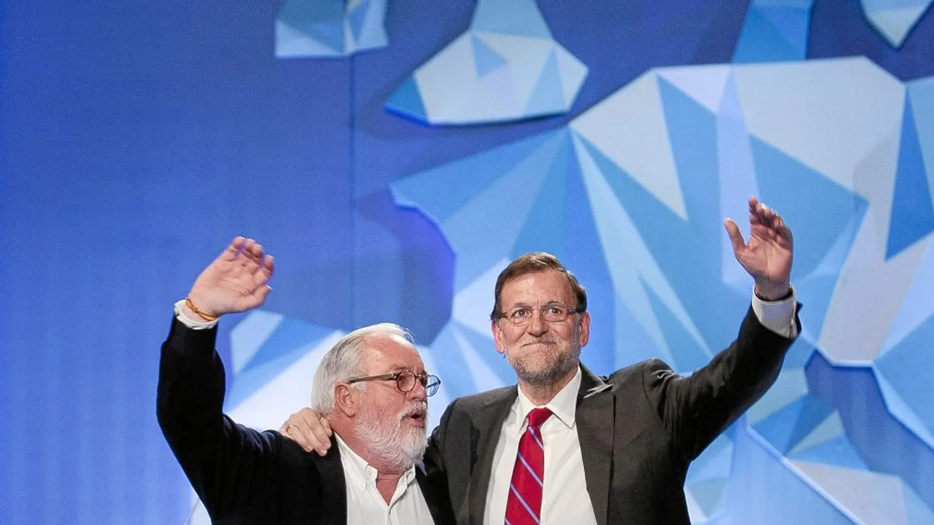 El presidente del Gobierno, Mariano Rajoy (d) y el cabeza de lista del PP a las elecciones europeas, Miguel Arias Cañete, saludan durante el mitin de cierre de la campaña