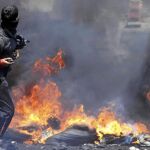 «MUERTE A ISRAEL» La protesta antes y después del funeral se sucedió bajo este grito del odio. En la imagen, un palestino lanza una piedra durante los enfrentamientos entre palestinos y soldados israelíes en el barrio de Kofr Kedum