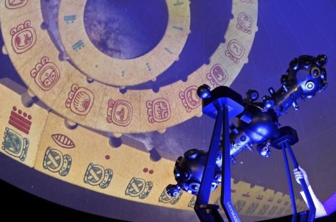 Una mujer observa una proyección del calendario maya en un planetario 