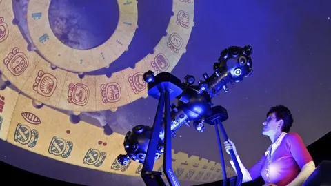 Una mujer observa una proyección del calendario maya en un planetario