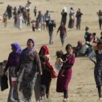 Un grupo de desplazados caminan cerca de la frontera con Siria.