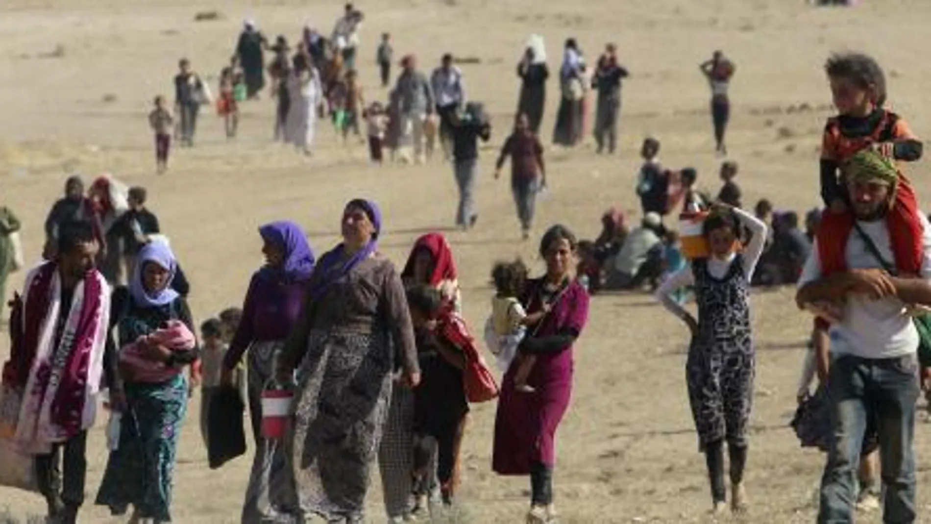 Un grupo de desplazados caminan cerca de la frontera con Siria.