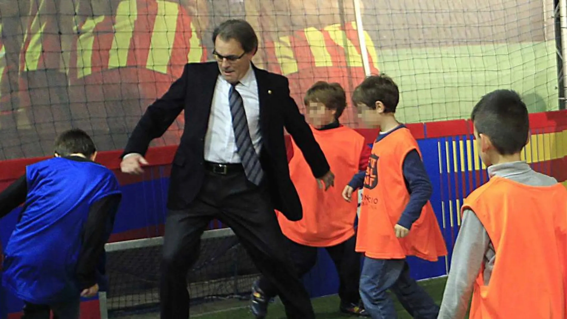El presidente de la Generalitat, Artur Mas, juega al fútbol con unos niños en el Festival de la Infancia