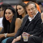 Imagen de archivo fechada en octubre de 2013, de Donald Sterling, y su novia, V. Stiviano, durante un partido de los Clippers