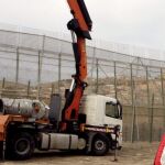 Una máquina trabaja en la colocación de la concertina a lo largo del perímetro fronterizo de Melilla