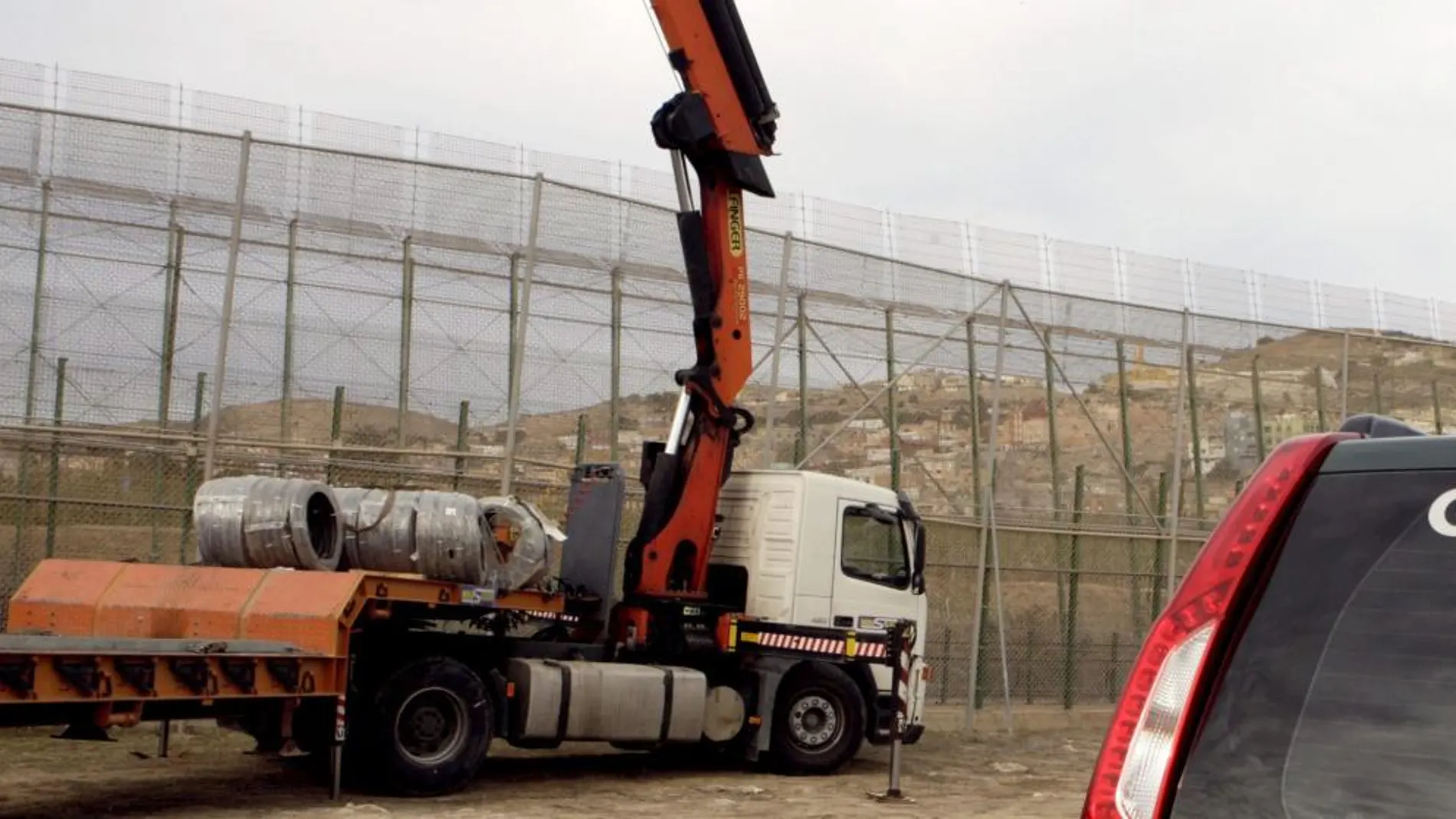 Una máquina trabaja en la colocación de la concertina a lo largo del perímetro fronterizo de Melilla