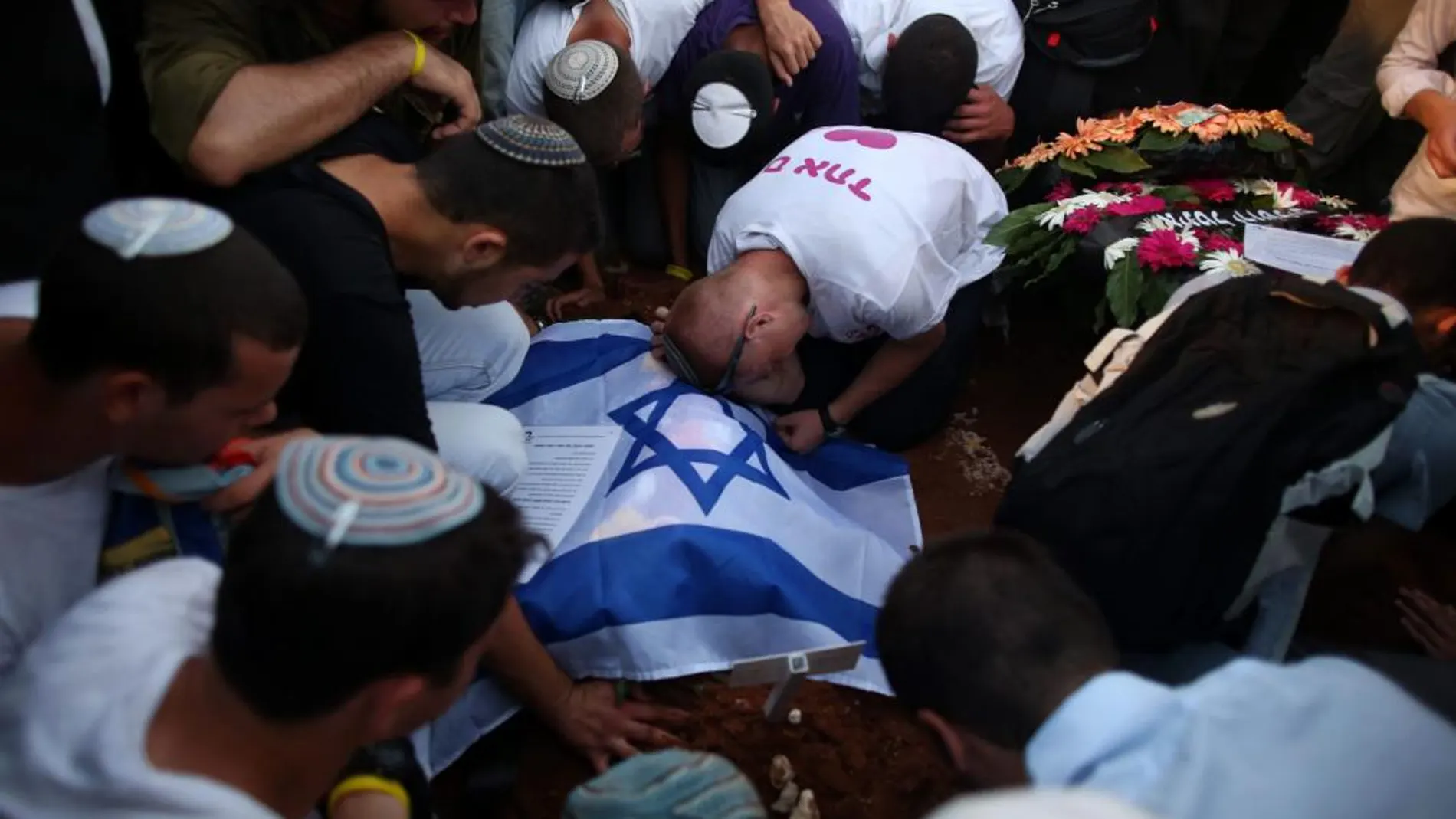 Amigos de Gil-Ad Shaer, uno de los tres jóvenes israelíes asesinados, asisten al funeral colectivo que se lleva a cabo en Modi'in (Israel).