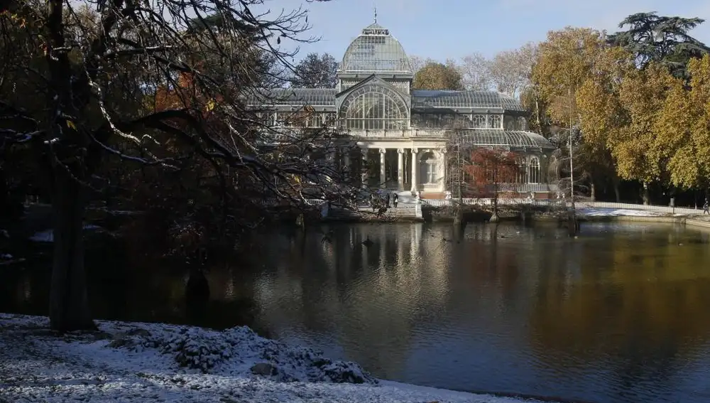 El Palacio de Cristal del Retiro ha amanecido hoy cubierto por una pequeña nevada.