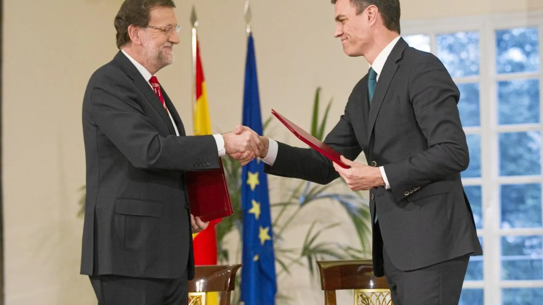 El presidente del Gobierno, Mariano Rajoy, y el líder de la oposición, Pedro Sánchez, se estrechan la mano tras rubricar el pacto antiterrorista en La Moncloa