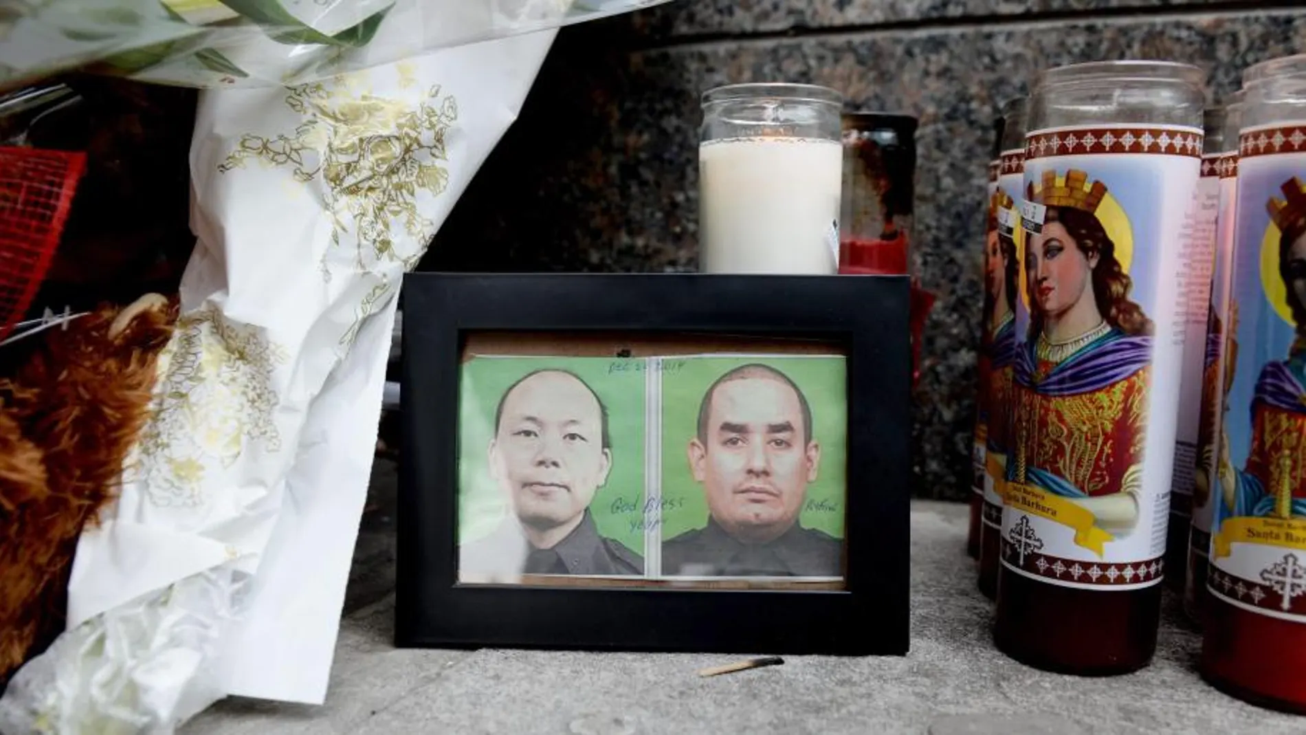 Dos fotografías de los agentes asesinados, flores y velas en memoria de los policias
