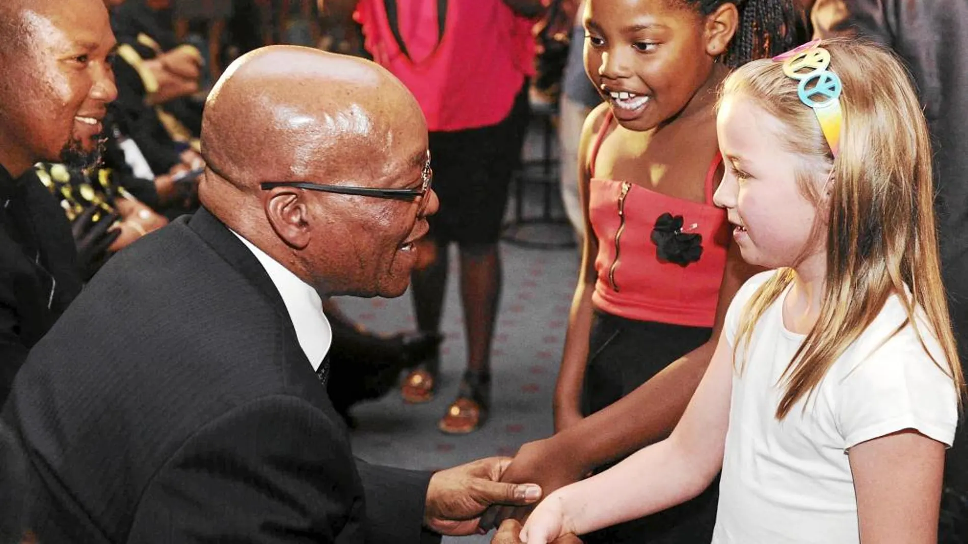 EN BUSCA DE LA FOTO. El presidente surafricano, Jacob Zuma, saluda a unas niñas en la iglesia metodista de Bryanston, ayer en Johannesburgo