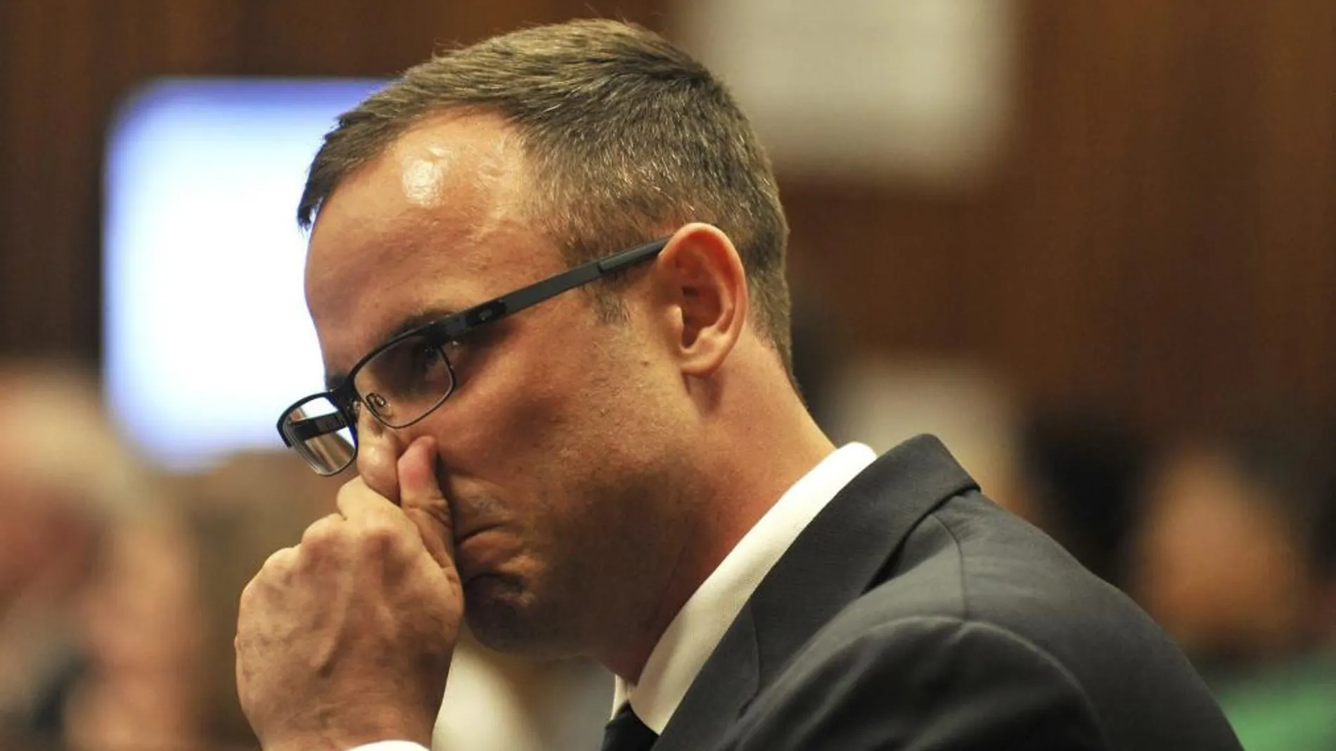 El atleta paralímpico Óscar Pistorius llora hoy en el banquillo de los acusados durante su juicio por asesinato
