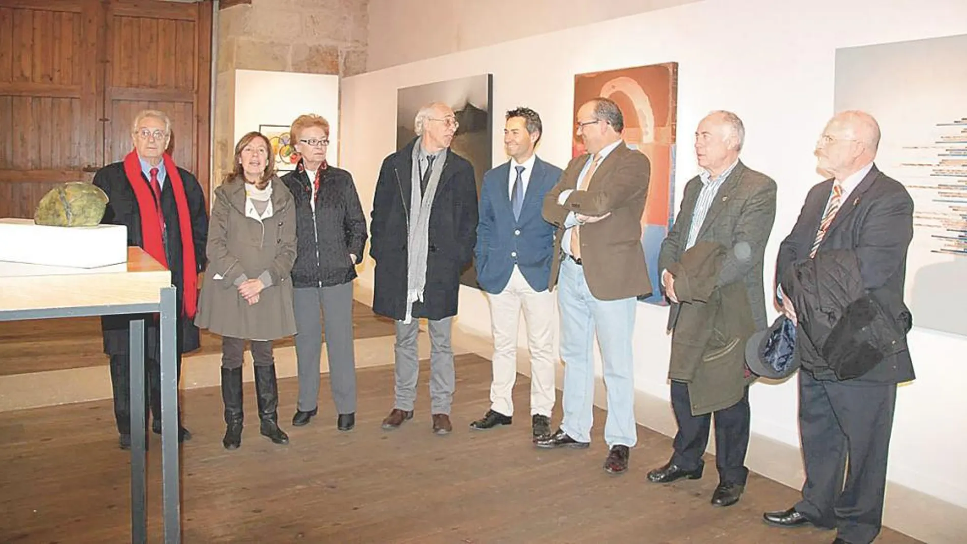 La comisaria de la exposición, María Teresa Alario, explica una obra a Ana Alonso y Alberto Jiménez-Arellano Alonso, entre otros