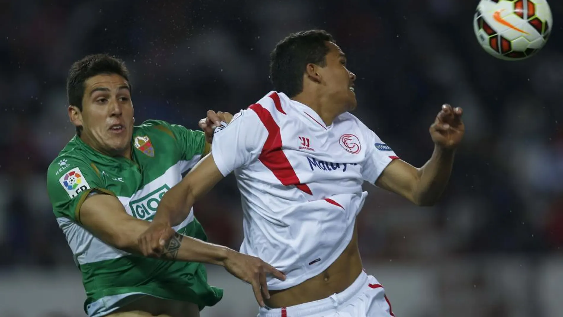 El delantero colombiano del Sevilla Carlos Arturo Bacca y el defensa chileno del Elche Enzo Roco