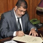 Mohamed Mursi firma el decreto para aprobar la nueva Constitución, en El Cairo