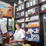 Una farmacéutica de Valladolid atiende a un pensionista