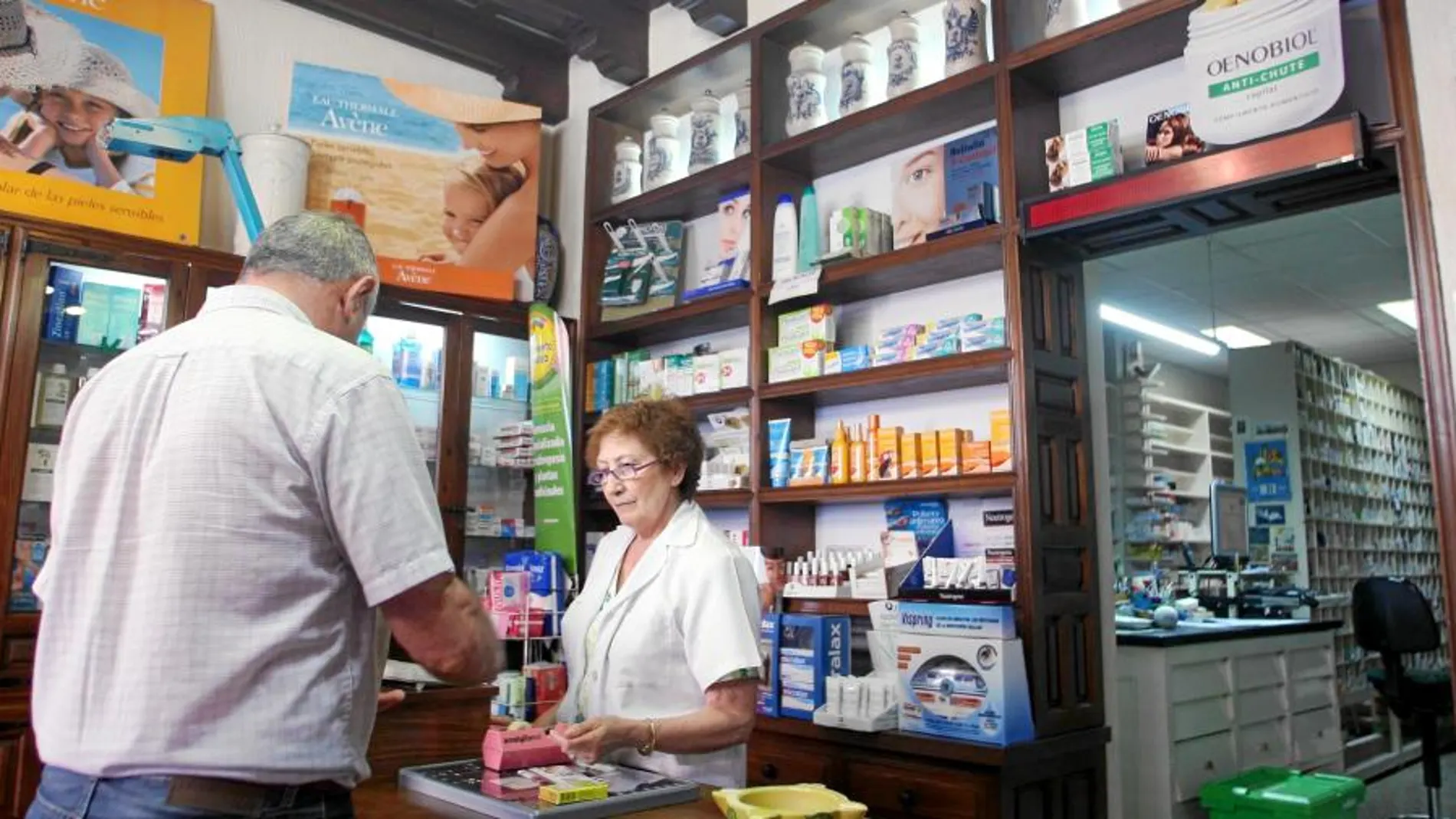 Una farmacéutica de Valladolid atiende a un pensionista