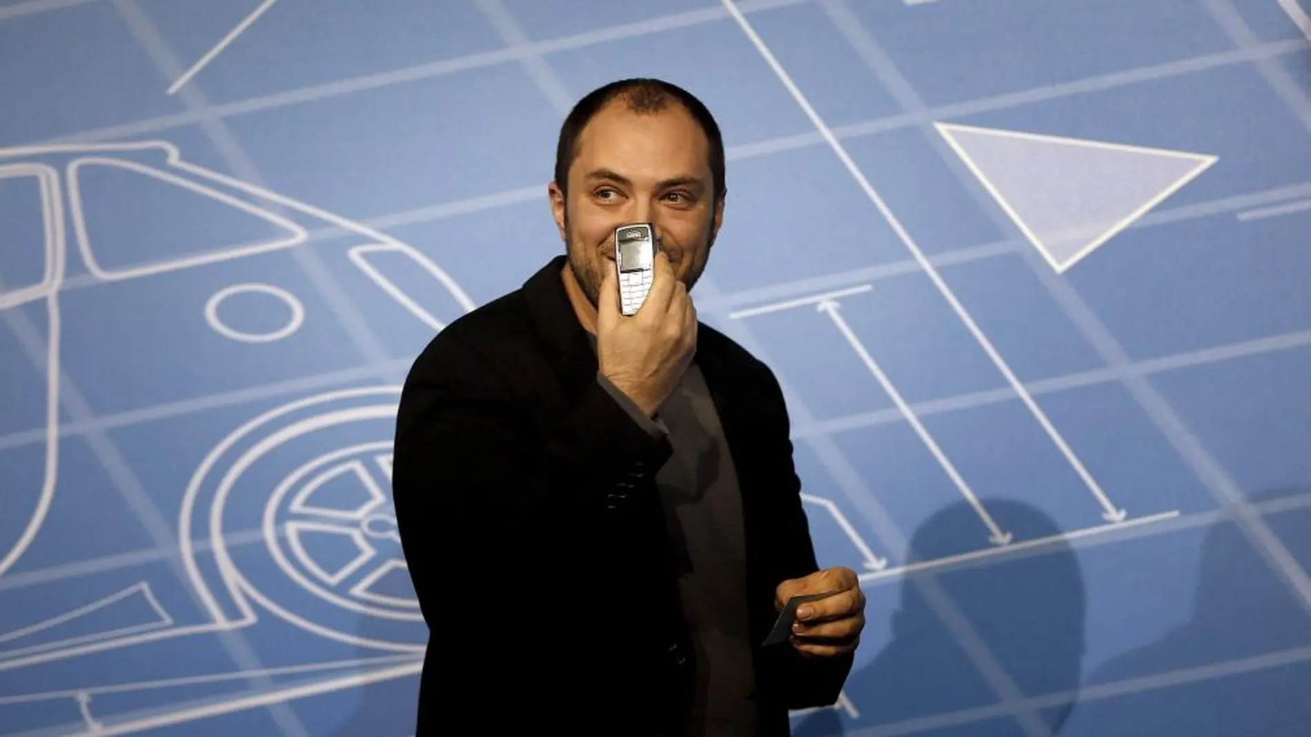 El cofundador de WhatsApp, Jan Koum, muestra su móvil personal durante su intervención en uno de los debates que se celebran en el Mobile World Congress.