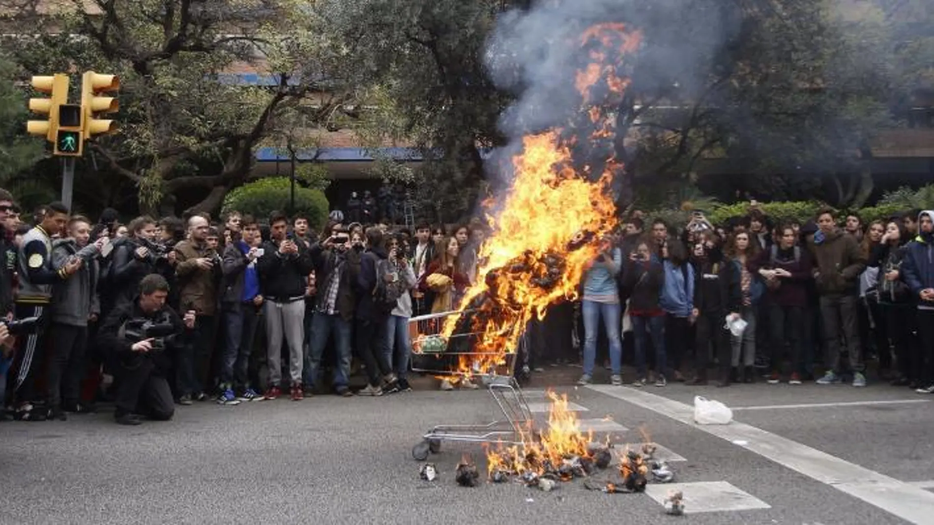 Un grupo de estudiantes queman diversos productos ante la sede de Educación de la Generalitat.