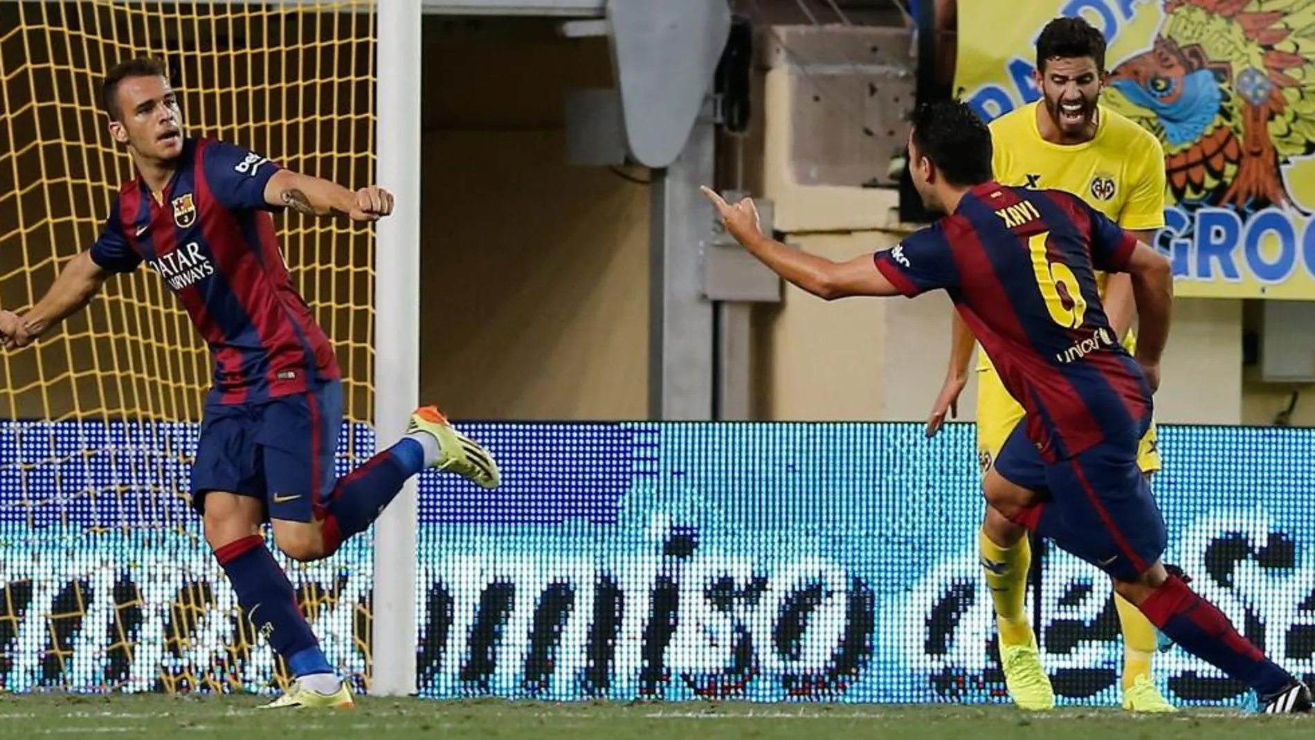El delantero del Barcelona Sandro Ramírez (i) celebra con su compañero Xavi Hernández la consecución del primer gol de su equipo ante el Villareal