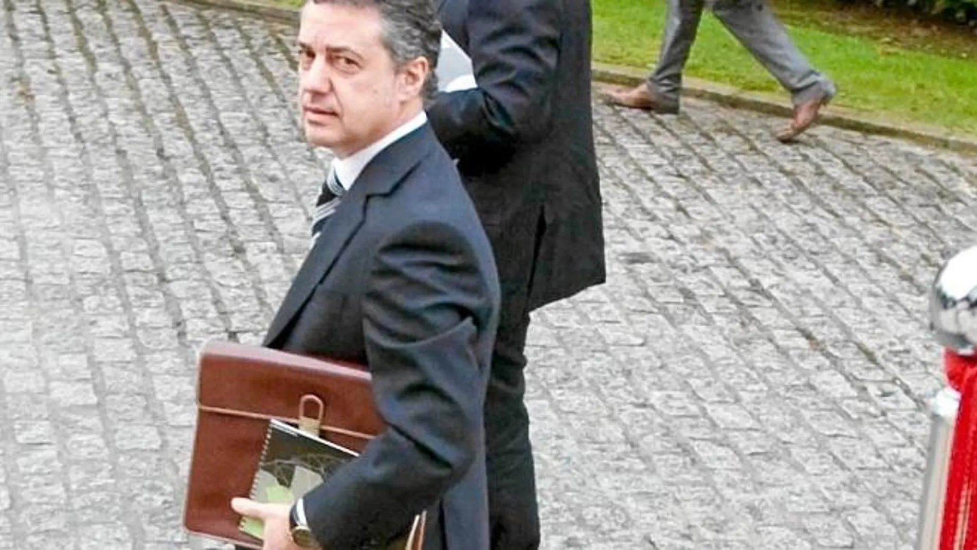 El entonces presidente del PNV, Iñigo Urkullu, pasa ante una bandera española en la sede del Gobierno vasco, en Vitoria, en 2009