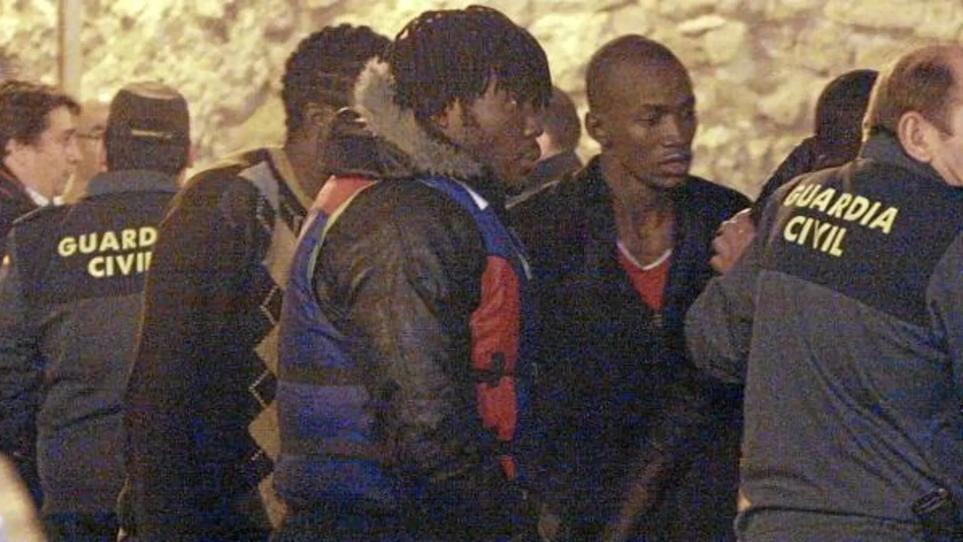 Miembros de la Guardia Civil atienden a algunos inmigrantes de origen subsahariano que llegaron a la frontera de España