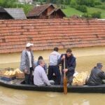 Vecinos de Pozega, 200 kilómetros al sur de Belgrado, reman en un bote sobre la ciudad inundada.