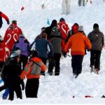 Miembros de los servicios de rescate y turistas buscan a varios excursionistas atrapados por una avalancha en Suiza