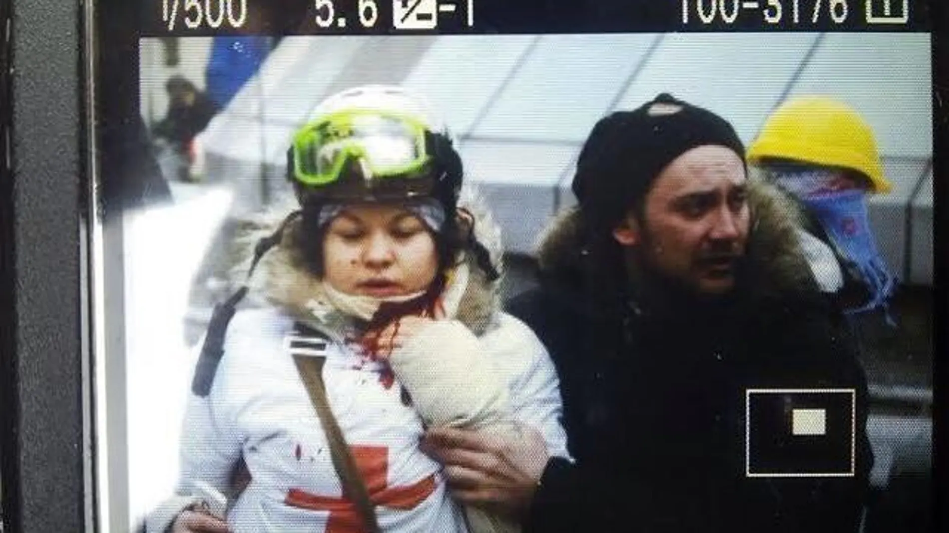 Un activista protege a Olesya Zhukovskaya tras recibir el disparo en el cuello