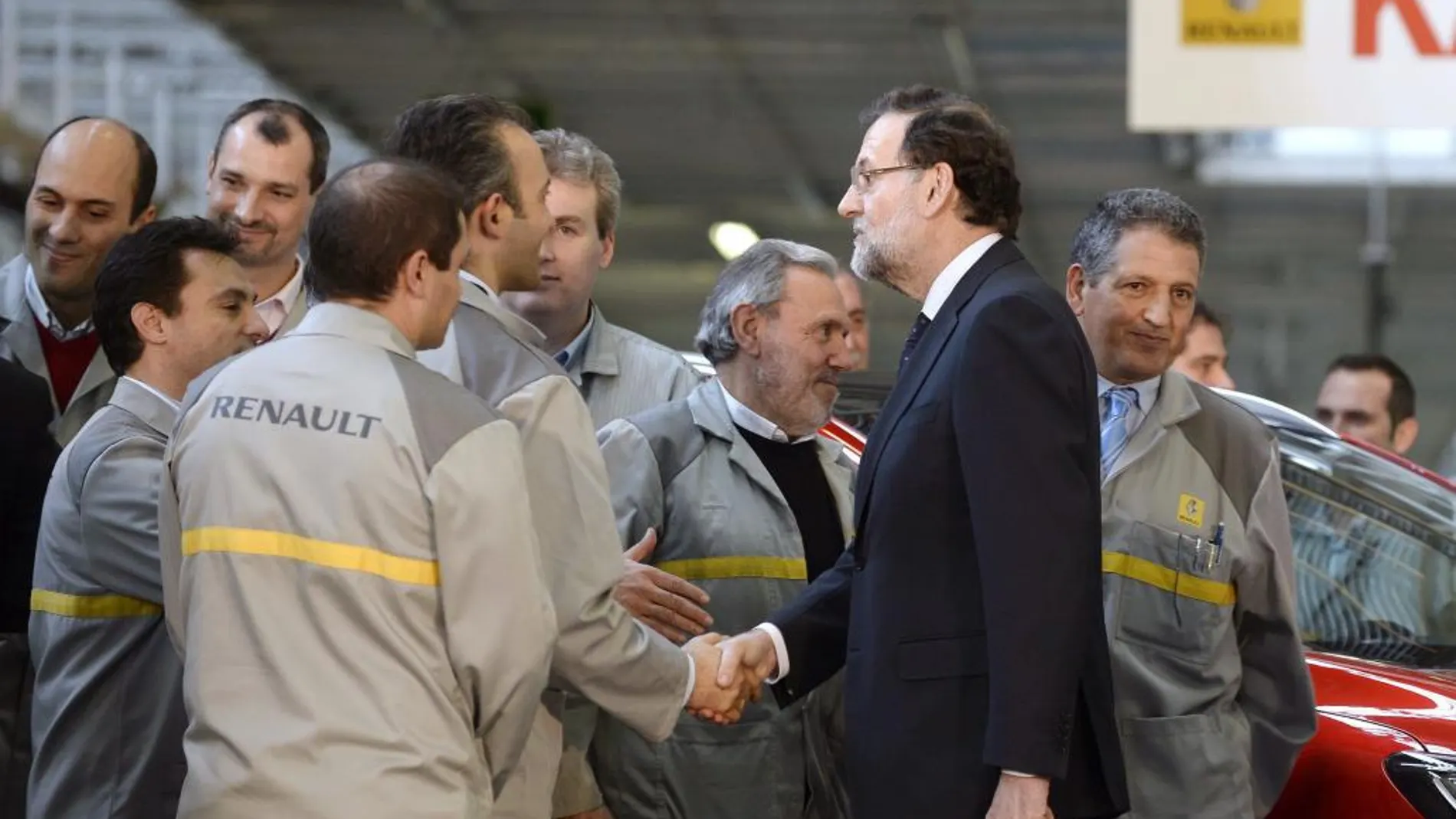 El presidente del Gobierno, Mariano Rajoy, saluda a un grupo de trabajadores