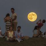 Un grupo de pesonas admira la superluna a las afueras de Madrid