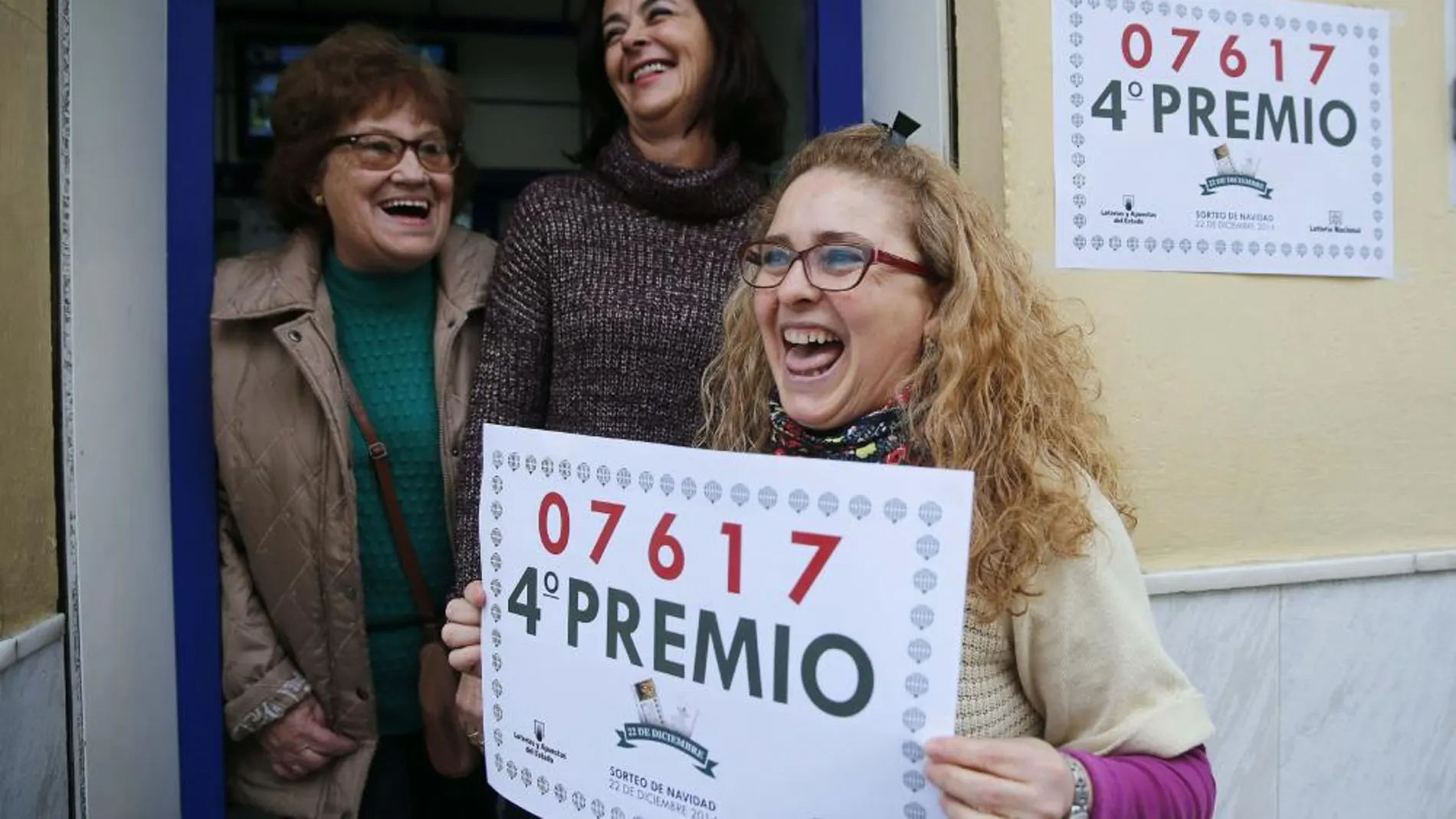 Rosario Pino, empleada de la administración situada en la calle José Tallaví junto a la titular de dicho establecimiento Isabel Valenzuela (c), sostiene un cartel con el 4º Premio, 07617