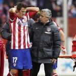 El centrocampista del Atlético Manquillo se retira del terreno de juego tras sufrir una brutal caída con el cuello