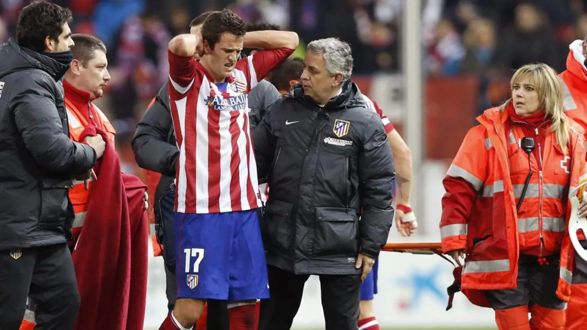 El centrocampista del Atlético Manquillo se retira del terreno de juego tras sufrir una brutal caída con el cuello