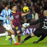 Leo Messi (c) lucha el balón con el portero argentino Willy Caballero (d) y el defensa portugués Flavio Ferreira (i), del Málaga CF.