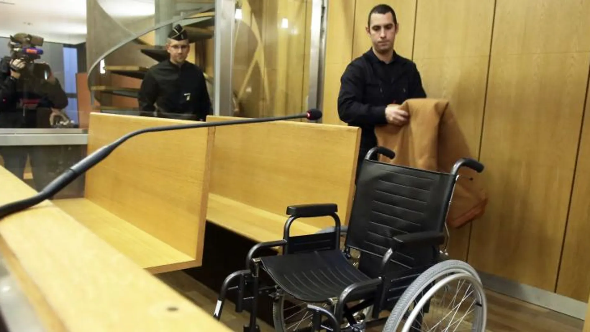 Un gendarme prepara la silla de ruedas que ocupará Pascal Simbikangwa en el Tribunal