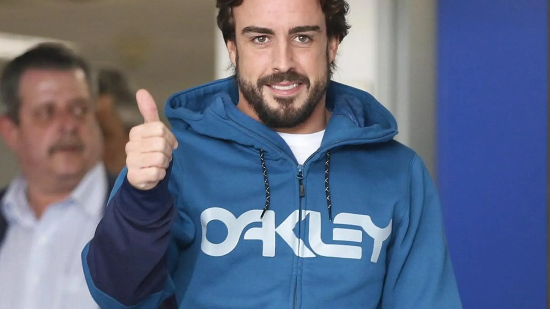 El piloto español Fernando Alonso saluda al salir del hospital