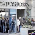 Largas colas de clientes de BPA a las puertas de una oficina de la entidad, ayer, en Andorra