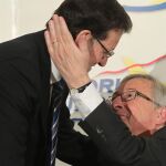 El candidato del Partido Popular Europeo a la Presidencia de la Comisión Europea, Jean-Claude Juncker, saluda al presidente del Gobierno, Mariano Rajoy