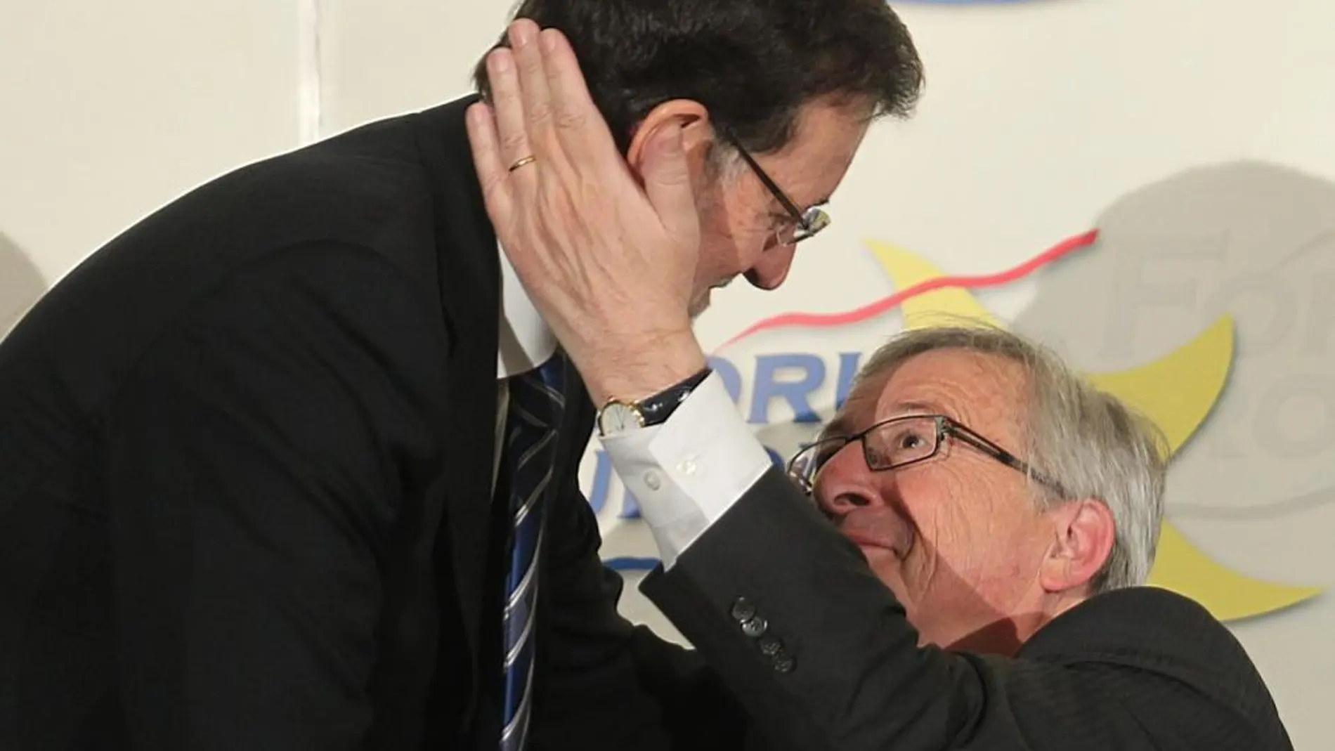 El candidato del Partido Popular Europeo a la Presidencia de la Comisión Europea, Jean-Claude Juncker, saluda al presidente del Gobierno, Mariano Rajoy