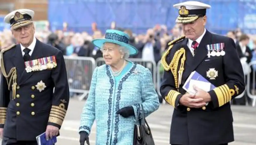 La reina Isabel II de Inglaterra (c) y a su esposo, el duque Felipe de Edimburgo (i), durante un acto en el que la soberana bautizó un portaaviones que lleva su nombre en los astilleros de Rosyth, en el condado de Fife, oeste de Escocia.