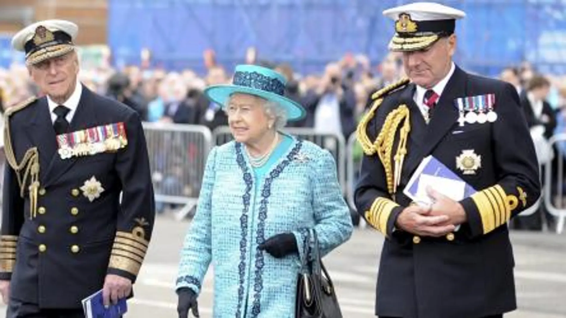 La reina Isabel II de Inglaterra (c) y a su esposo, el duque Felipe de Edimburgo (i), durante un acto en el que la soberana bautizó un portaaviones que lleva su nombre en los astilleros de Rosyth, en el condado de Fife, oeste de Escocia.