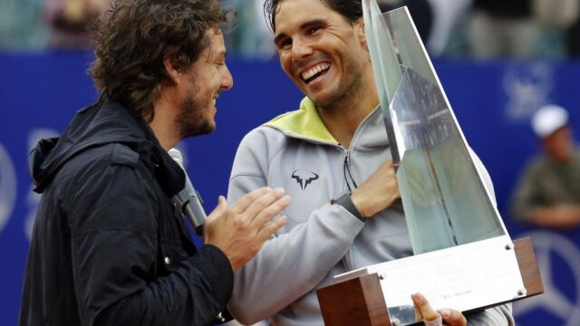 Rafael Nadal (d) recibe el trofeo de manos del excampeón de Roland Garros, Gaston Gaudio