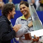 Rafael Nadal (d) recibe el trofeo de manos del excampeón de Roland Garros, Gaston Gaudio