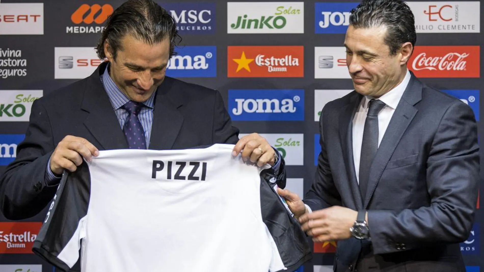 El nuevo entrenador del Valencia, Juan Antonio Pizzi (izqda), muestra una camiseta del conjunto valencianista, junto al presidente Amadeo Salvo, esta tarde durante el acto de su presentación oficial.