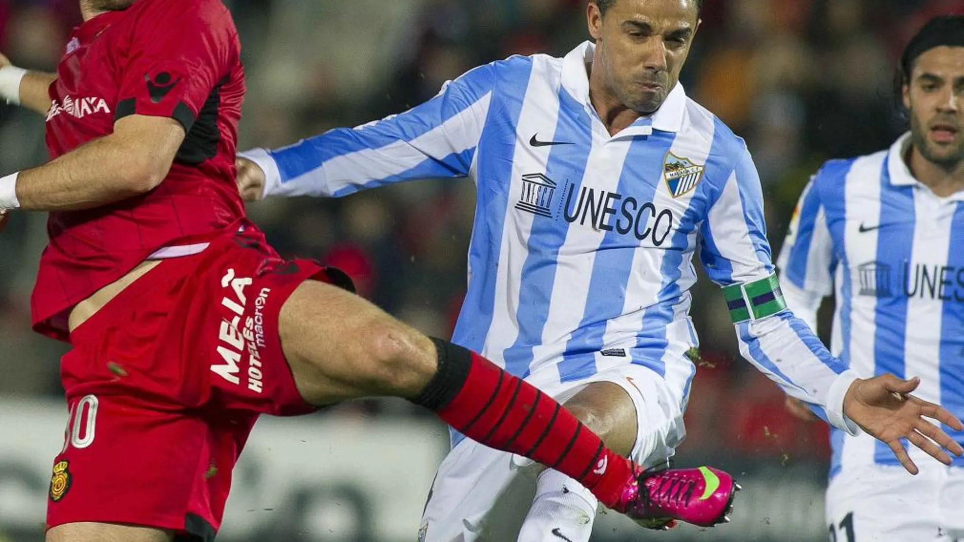 El delantero israelí del RCD Mallorca Tomer Hemed, disputa el balón al defensa brasileño del Málaga CF Weligton de Oliveira (d)