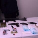 En la imagen se ven tres pistolas, un fusil, algunos temporizadores y unas cuantas bolsas de explosivo.