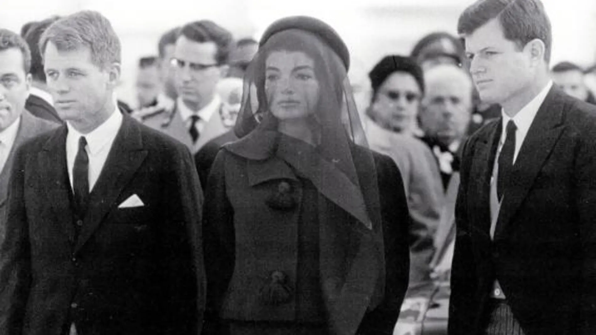 Jackie, entre Robert y Edward Kennedy, en el adiós a JFK