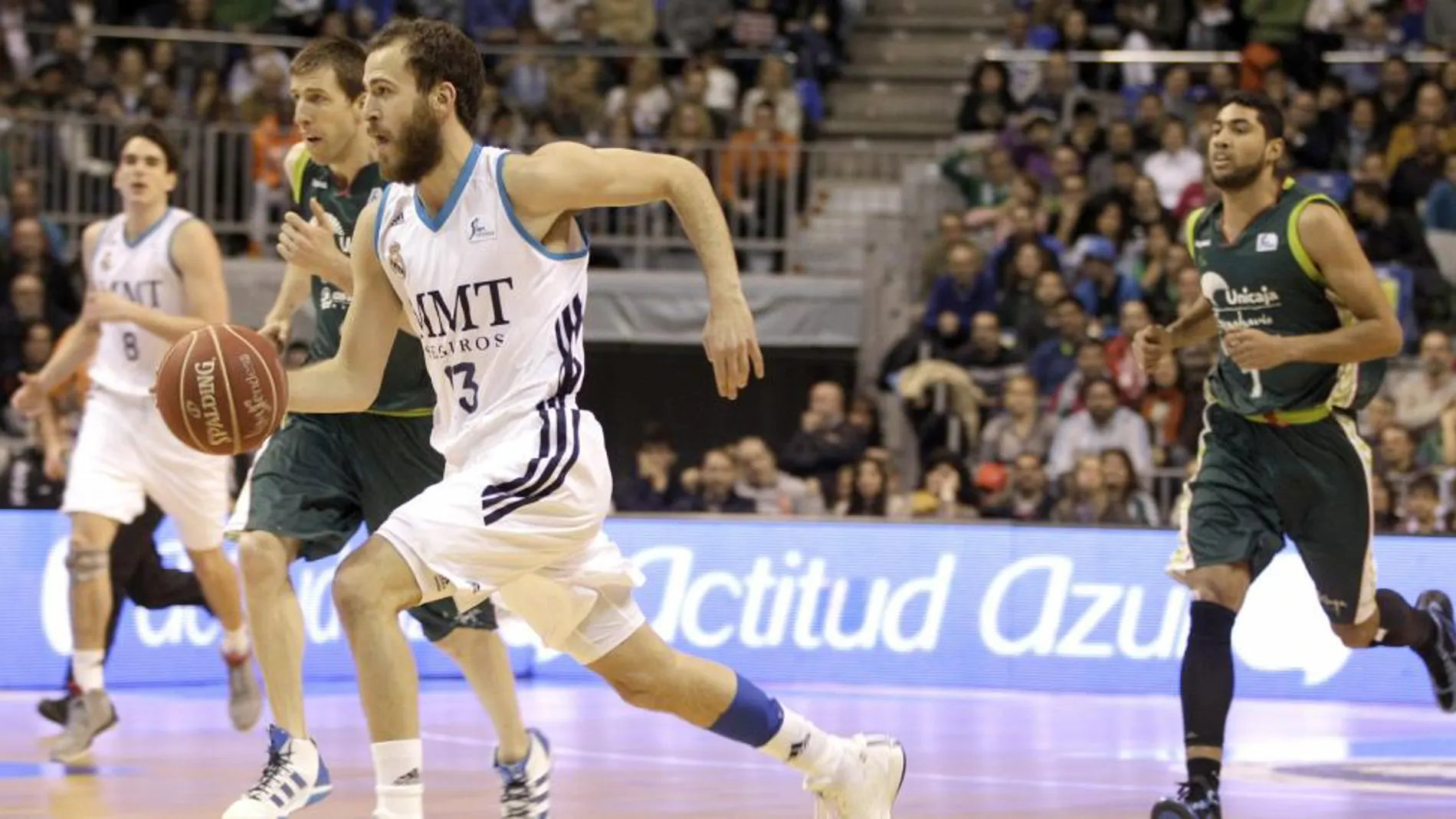 El base del Real Madrid, Sergio Rodríguez, corre con el balón ante los jugadores del Unicaja, el pívot Fran Vazquez y el ala-pívot Augusto Cesar Lima